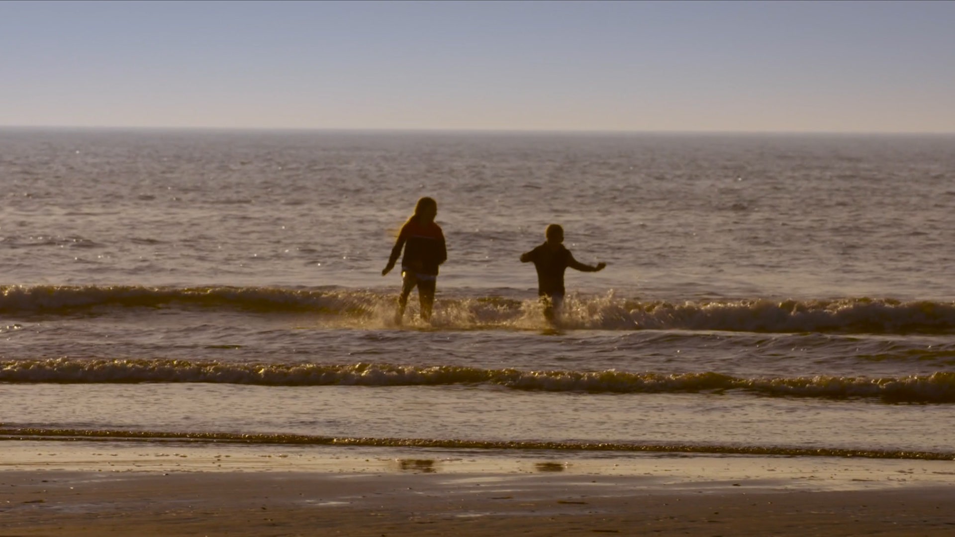 Two children running in the sea during golden hour.jpg